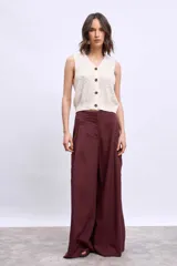 Chaleco de punto color beige, sin mangas, con escote en V y cierre frontal con botones de madera.