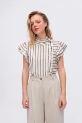Remera de manga corta con rayas verticales en tonos beige y marrón, cuello alto con volados, cierre frontal con botones en diagonal y detalles de volados en las mangas y el delantero.