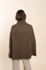 Capa color beige con textura de espiga, cuello alto con botones y aberturas laterales para los brazos. Confeccionada en lana fina sin teñir.