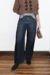 Jean de corte balloon con pierna ancha y tiro medio-alto. Presenta un diseño de costuras verticales en el frente y bordados en los bolsillos traseros.