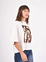 Remera negra de corte holgado con estampa frontal de línea abstracta en color blanco.