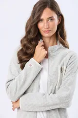 Campera de micropolar con textura en relieve, cierre frontal completo y cuello alto. Presenta un bolsillo vertical con cierre en el pecho y detalles de terminación en color contrastante.