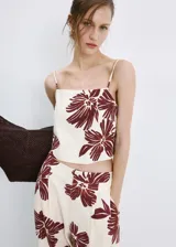 Top de tirantes finos con escote cuadrado, de corte recto y estampado floral en tonos bordó sobre base beige.