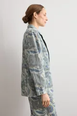 Blazer de jean con estampado paisley en tonos azules y tostados, solapas clásicas y mangas largas.