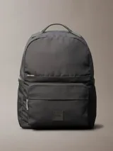 Mochila de poliéster reprocesado color gris oscuro/negro, con asa de mano superior y correas de hombro acolchadas. Presenta doble compartimento principal con cremallera, doble bolsillo exterior frontal con cremallera y parche con logotipo en la parte delantera.