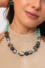 Collar corto con cuentas de nácar teñido, cerámica y cristales de murano en tonos turquesa, verde oscuro y marrón.