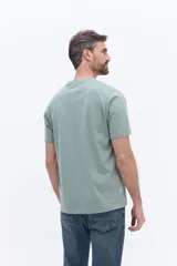 Remera de manga corta color verde menta, con cuello redondo y corte regular. Presenta un estampado frontal con flores blancas sobre un recuadro rectangular de color marrón y el logo de la marca Brooksfield.