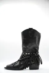 Bota de cuero negro estilo texano, con taco bajo y punta fina. Incluye un aplique desmontable en la zona del empeine decorado con tachas metálicas y flecos largos.