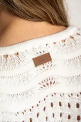 Sweater de punto calado con diseño de ondas horizontales, cuello redondo y mangas largas. Presenta un corte oversize y acabado en color blanco.
