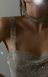 Top corto plateado con strass, breteles anchos y espalda regulable.