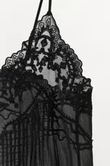 Top lencero de tirantes finos ajustables, confeccionado en tejido semitransparente con detalles de bordados y abalorios a tono en el escote.