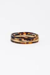 Pulsera rígida combinada de acetato con estampado carey y aros metálicos en tono dorado mate.