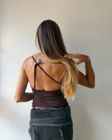 Top de lycra color chocolate con escote halter, detalle de tachas metálicas en los bordes y diseño para atar al cuello.