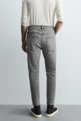 Jeans de hombre, corte skinny y largo cropped, color negro lavado. Presenta cinco bolsillos y cierre frontal con cremallera y botón.