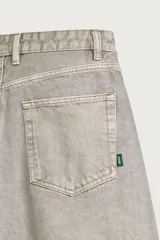 Pantalón barrel fit de mezclilla color verde militar, con efecto lavado, cinco bolsillos, cierre frontal con cremallera y botón, y detalle de pinzas en las rodillas.