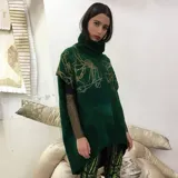 Poncho verde esmeralda de lana merino afieltrada con cuello alto y estampado dorado con diseño abstracto.