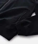 Campera estilo bomber de color negro, confeccionada con tejido repelente al agua. Posee cuello semi alto, cierre frontal con cremallera, bolsillos laterales y puños y dobladillo elastizados. Marca Marfinno.