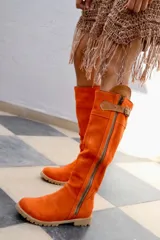 Botas altas de gamuza color rojo con forro de cuero, cierre lateral y suela de goma.