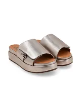 Sandalia de cuero color peltre, con plataforma, tira ancha con ajuste de velcro y aplique metálico ornamental.