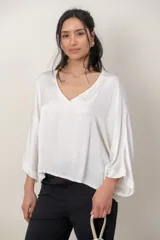 Blusa italiana de viscosa color beige, de calce holgado, con escote en V y detalle de lurex. Presenta mangas tres cuartos y diseño fluido.