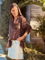 Camisa marrón de seda con bolsillo de cuero de vaca al frente, de corte holgado y mangas largas.