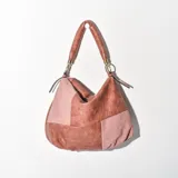 Cartera tipo hobo color rosa con diseño de bloques de cuero y gamuza.