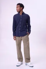 Pantalón de tela color caqui, corte recto y holgado, con cordón de ajuste en la cintura y bolsillos cargo laterales.