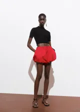 Short de gabardina color rojo con diseño abuchonado estilo globo, cintura elástica y bolsillos laterales.
