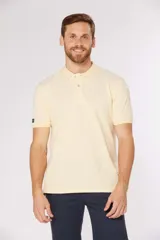 Remera polo lisa color amarillo pastel, confeccionada en piqué Oxford, con cuello en rib y botones personalizados.