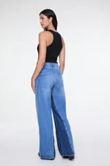 Pantalón de denim bicolor de tiro alto, corte amplio, diseño de cinco bolsillos y combinación de paneles en tonos de azul.