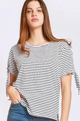 Remera de algodón a rayas horizontales blancas y negras, con cuello redondo y mangas cortas que presentan un detalle de lazo ajustable en los extremos.