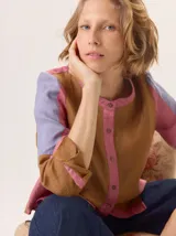 Camisa de algodón con diseño de bloques de color en tonos marrón, rosa y lila. Presenta cuello redondo, cierre frontal con botones y mangas largas.
