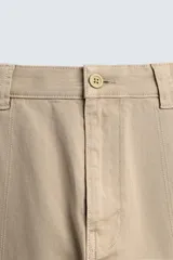 Pantalón cargo de corte relajado confeccionado en tejido de algodón con elasticidad. Presenta bolsillos laterales tipo cargo con solapa en las perneras, bolsillos frontales y bolsillos traseros de doble vivo. Cierre frontal con cremallera y botón.