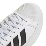 Championes Adidas de plataforma con diseño inspirado en el tenis clásico. Presentan un exterior de cuero sintético blanco con las icónicas tres tiras laterales en negro y detalle en el talón del mismo color. Cuentan con una suela de plataforma robusta y cómoda.