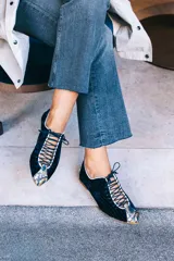Zapato tipo blucher de terciopelo de seda azul marino con diseño rayado. Presenta una abertura central ajustable con cordones, ribetes en contraste y detalles en piel con estampado de pitón multicolor en la puntera y el talón. Cuenta con suela de cuero.