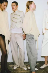 Jeans de tiro alto, corte ancho y pierna recta, color beige claro con efecto lavado. Presenta trabillas en la cintura, bolsillos delanteros y traseros, y cierre frontal con cremallera y botón.