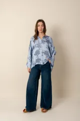 Camisa celeste con estampado floral en azul marino, de corte amplio y mangas largas.