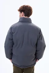 Campera puffer negra de corte estándar, con cuello alto, cierre frontal completo y puños elásticos.