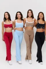 Conjunto deportivo compuesto por un top corto con cuello redondo y ribete blanco, y un pantalón largo de tiro alto con corte acampanado en el bajo.