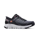 Championes deportivos Skechers Hands Free Slip-ins Summits AT, color gris y negro con detalles en naranja. Diseñados con tecnología Heel Pillow, capellada de malla resistente, entresuela flexible con absorción de impactos y plantilla Air-Cooled Memory Foam.