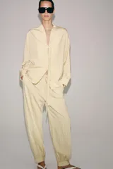 Pantalón bombacho de tiro medio, confeccionado en hilatura con mezcla de viscosa, con estampado de rayas verticales en tonos beige y amarillo claro, cintura elástica ajustable con cordón y puños en los tobillos.