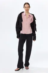 Camisa entallada de mezcla de viscosa en color rosado, con efecto arrugado y bajo levemente acampanado. Presenta cuello camisero, cierre frontal de botones, canesú en la espalda y pliegues en la cintura que definen la silueta. Cuenta con mangas largas y puños abotonados.