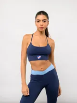 Top deportivo de color azul marino con tirantes finos y espalda cruzada. Presenta el escudo oficial del Club Nacional de Football estampado en el centro del bajo.