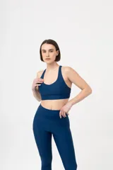 Calza larga deportiva color verde oscuro, de tiro alto, con bolsillos laterales y costuras reforzadas.