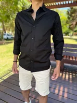 Camisa clásica negra de manga larga con botones frontales y cuello camisero.