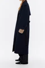 Abrigo maxilargo doble faz con mezcla de lana en color marino con interior en color marrón. Modelo con escote con maxisolapas, manga larga con puño y trabillas, y cierre frontal con doble botonadura. Canesú en el delantero y la espalda, cinturón de tejido y bolsillos con vivo.