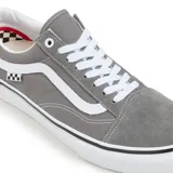 Championes Vans modelo Skate Old Skool, color gris, con diseño clásico de caña baja, paneles de gamuza y lona, banda lateral característica en color blanco y suela de goma vulcanizada.