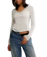 Top de manga larga ajustado de punto ligero tipo pointelle, color blanco, con escote en V ribeteado con encaje negro y blanco.