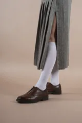 Falda midi gris con diseño de espiga, corte evasé y abertura frontal.