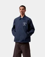 Campera estilo coach jacket de Carhartt WIP color azul marino, confeccionada en lona de nailon de peso medio, sin forro. Presenta cierre frontal de botones a presión, cuello camisero, dos bolsillos delanteros ribeteados y bordado gráfico en contraste en el pecho.